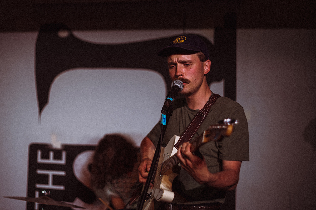person singing and playing guitar at show