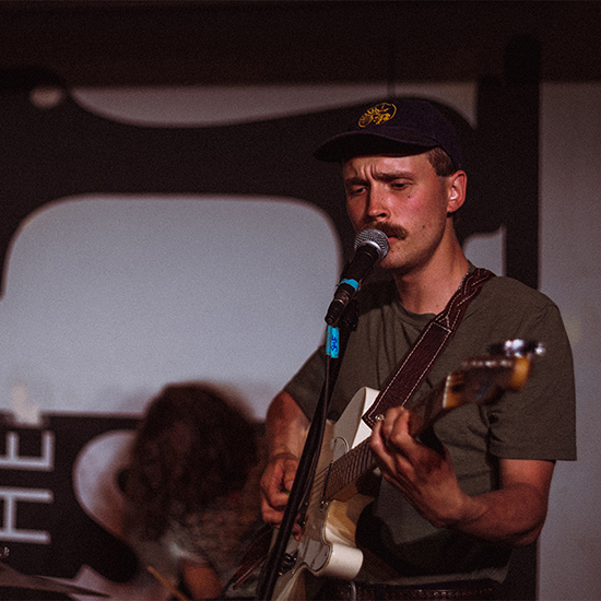 person singing and playing guitar at show